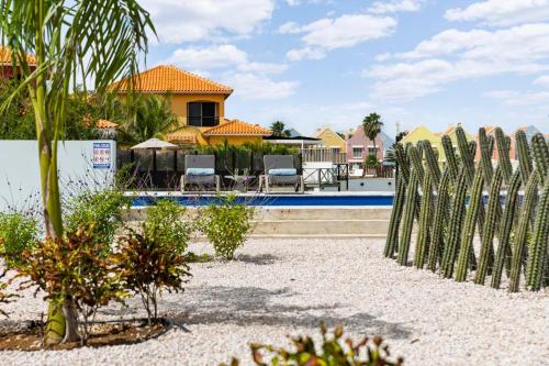 a fence in front of a house with a pool at Vacation Home Bonaire in Kralendijk