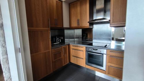 - une cuisine avec des placards en bois et une cuisinière dans l'établissement Superbe Appartement Rue Royale - Gregoire, à Lille