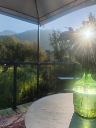 a vase sitting on a table with the sun shining in it at Cabaña Mirador in Quillota