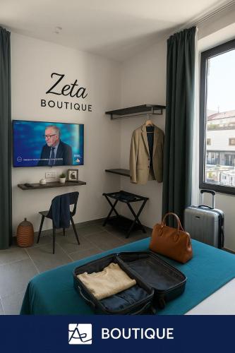 a room with a bed with a television and a suitcase at Zeta Boutique in Caserta