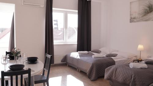 a room with two beds and a table and a window at MIRA apartments in Prague