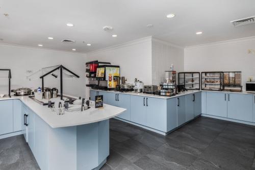 une grande cuisine avec des armoires et des appareils bleus dans l'établissement Staybridge Suites Madison - East by IHG, à Madison