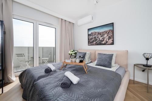 Manufaktura Suites - 76m2, Parking, AirCon - by Rentujemy في لودز: غرفة نوم بسرير وطاولة مع مخدات