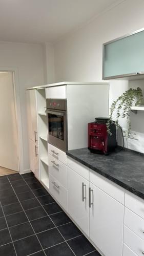 a kitchen with white cabinets and a red appliance at Ferienhaus Ruhepol in Bad Harzburg