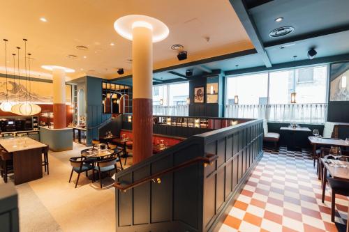 a restaurant with tables and chairs and a bar at The Marcus Portrush, Tapestry Collection By Hilton in Portrush