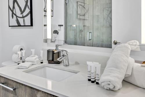 a white bathroom with a sink and a mirror at Sunset Waterview Oasis Studio in Miami