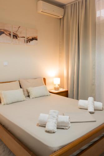 a large white bed with two towels on it at Ifigenia sea view in Artemida