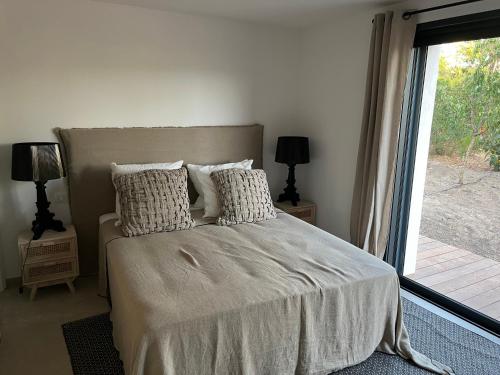 une chambre avec un lit et une grande fenêtre dans l'établissement A Cupulata, à Zonza