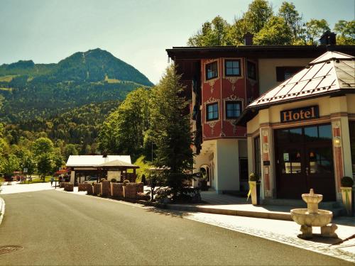 a hotel on the side of a street with a mountain at Hotel Königsseer Hof in Schönau am Königssee