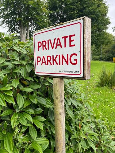 a private parking sign in front of a bush at Portora House Accommodation ROOM ONLY-ALL ROOMS EN-SUITE in Enniskillen