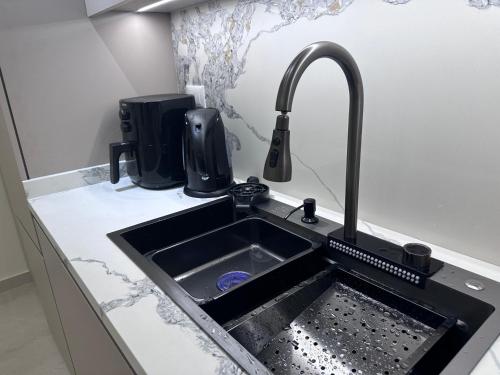 eine Küchenspüle mit einem Wasserhahn auf der Theke in der Unterkunft Water Front Luxury in Jnah Beirut 
