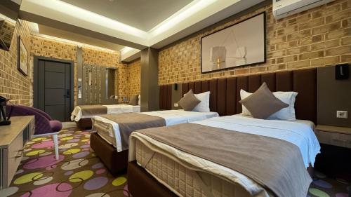 a hotel room with two beds and a tv at Art Air Hotel in Tashkent