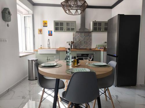 a kitchen with a wooden table and chairs with wine glasses at Maison au coeur de Banon in Banon