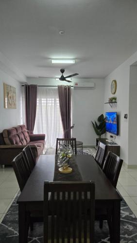 a living room with a table and chairs and a couch at Alanis Suite KLIA With Neflix in Sepang