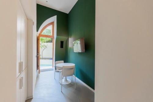 a dining room with green walls and a table and chairs at Assoli House in Naples