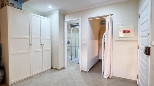a hallway with white cabinets and a walk in closet at Tróia 2 Minutes from the Beach in Troia