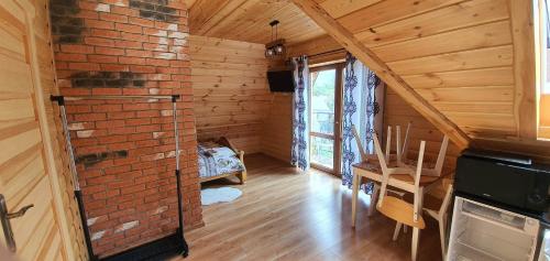 a room with a brick wall and a fireplace in a cabin at Pokoje u Ewy in Zakopane