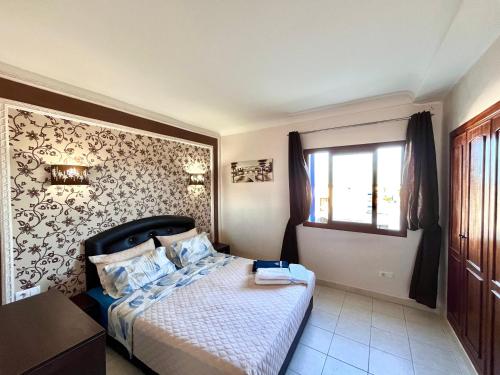 Un dormitorio pequeño con una cama y una ventana. en Appartement cosy à Kabila vue sur mer piscine et plage, en Oulad Akkou