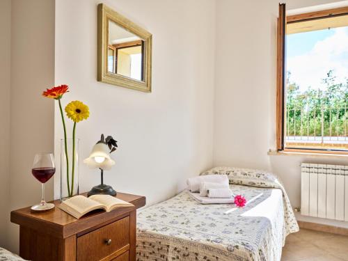 a bedroom with a bed and a table with a glass of wine at Casa Vacanze Santa Caterina in Asciano