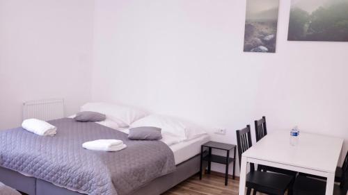 a bedroom with a bed with two pillows and a table at MIRA apartments in Prague