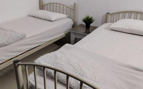 two twin beds in a room with a table at YUYU B2 Honeymoon WiFi Genting highland in Genting Highlands