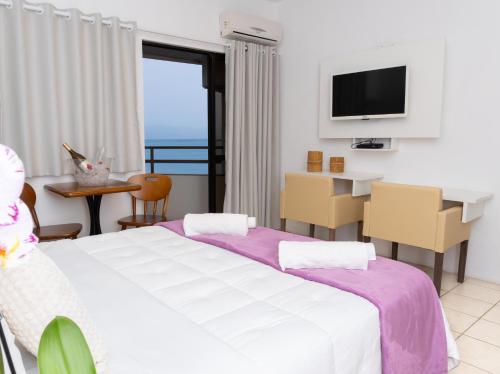 a hotel room with two beds and a television at Hotel Palace 1 in Florianópolis