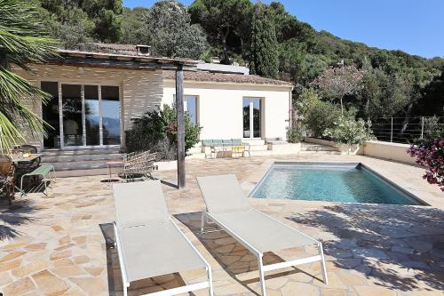 - une paire de chaises blanches à côté de la piscine dans l'établissement Villa Luma, 3 Chambres avec Piscine Chauffée, à Figari