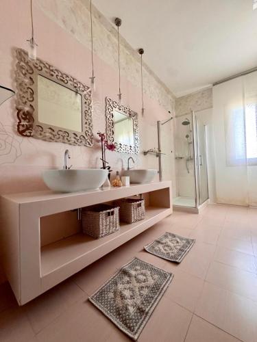 a bathroom with two sinks and two mirrors at Villa Erika in Gallipoli