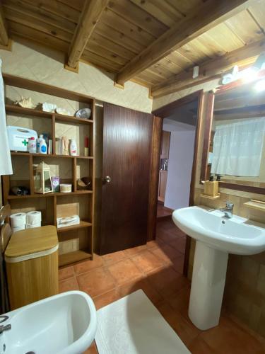 a bathroom with a sink and a bath tub at Casa do Caramba - The Dream House in São Roque do Pico