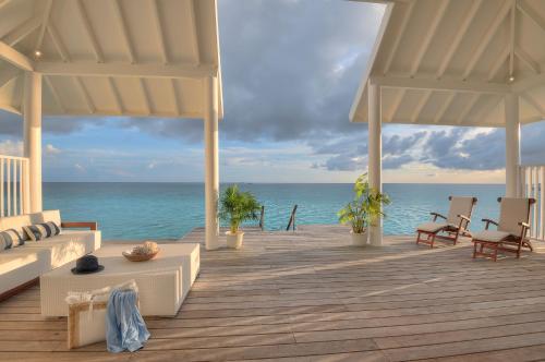 a wooden deck with a view of the ocean at Diamonds Athuruga Maldives Resort & Spa in Athuruga Island