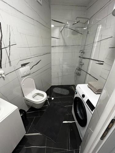 a black and white bathroom with a toilet and a shower at Monami - Apartman Simona in Vodice