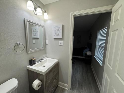 a bathroom with a sink and a toilet and a mirror at 4BR Ocean Springs Home with Luxury Amenities in Ocean Springs
