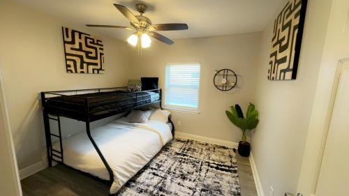 a bedroom with a black bunk bed and a ceiling fan at 4BR Ocean Springs Home with Luxury Amenities in Ocean Springs