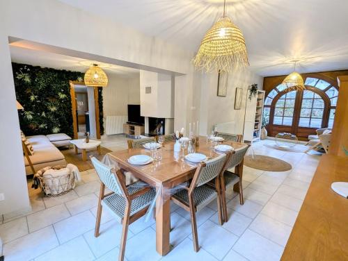 a dining room and living room with a table and chairs at L'échappée aux cerfs SPA in Les Rouges-Eaux