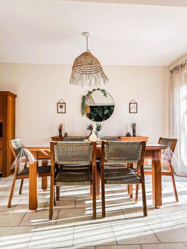 a dining room with a wooden table and chairs at L'échappée aux cerfs SPA in Les Rouges-Eaux