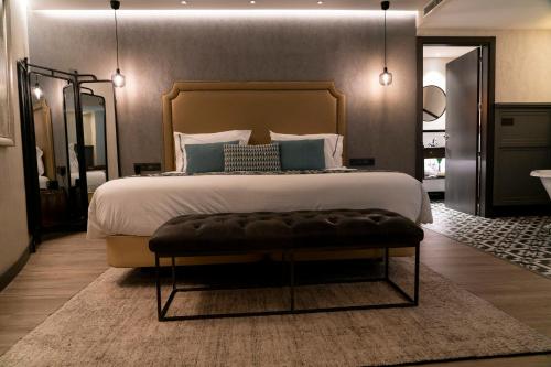 a bedroom with a large bed with a bench at the end at Hotel Indigo Madrid - Gran Vía by IHG in Madrid