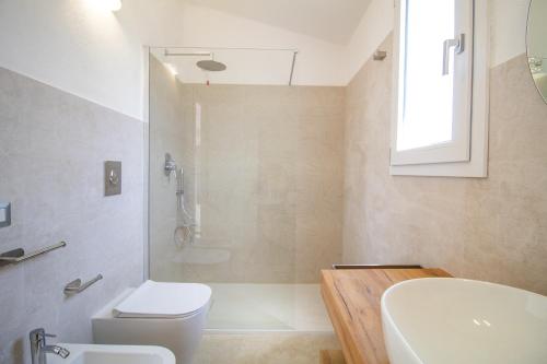 a bathroom with a toilet and a sink and a shower at Borgo Bianco affittacamere in Budoni