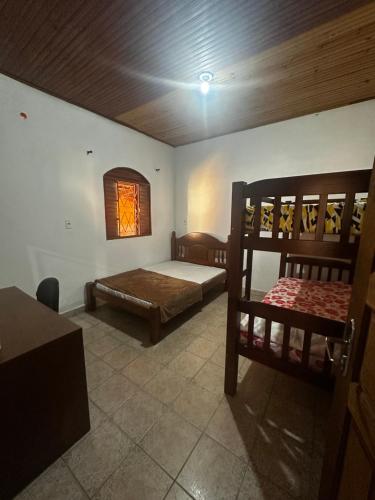 a bedroom with two bunk beds and a window at Residencial Divina in Pirenópolis