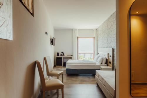 a bedroom with a bed and a desk and a chair at Villa Ersilia in Limone sul Garda