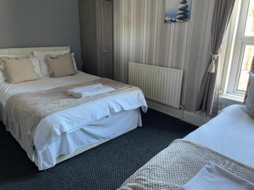 a bedroom with two beds and a window at Somerville Hotel in Blackpool