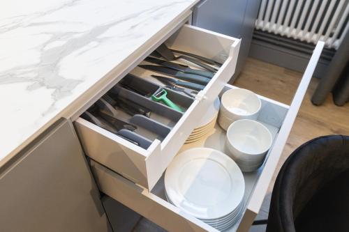 a drawer full of knives in a cabinet at Apartments Vitenberg in Cēsis