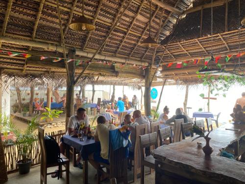 un grupo de personas sentadas en mesas en un restaurante en Sapphire Blue, en Hikkaduwa