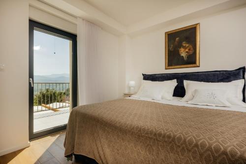 a bedroom with a bed and a large window at Vila Đirada in Imotski
