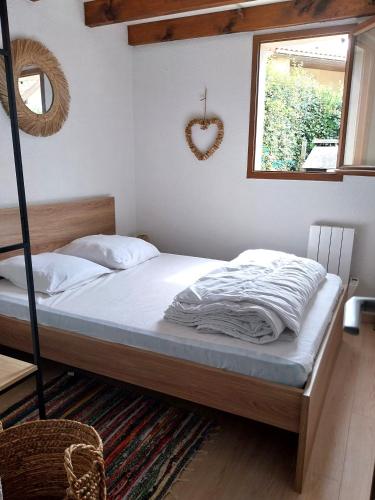 une chambre avec un lit et une fenêtre dans l'établissement Biscarrosse-plage jolie maisonnette avec terrasse privative - 200m de la plage, à Biscarrosse