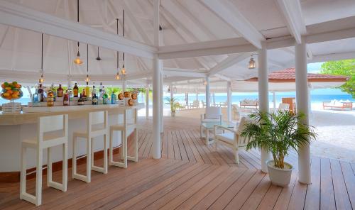 a bar on the beach with a view of the ocean at Diamonds Athuruga Maldives Resort & Spa in Athuruga Island