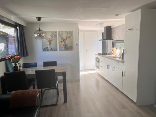 a kitchen with a table and a dining room at Het Eikenhuisje in Putten; huisje op de Veluwe. in Putten
