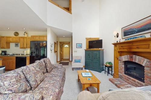 a living room with a couch and a fireplace at Jay Peak Townhouse in Jay