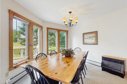 a dining room with a wooden table and chairs at Jay Peak Townhouse in Jay