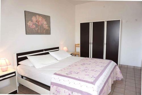 sypialnia z dużym łóżkiem z białymi prześcieradłami w obiekcie Apartment in Porto Santa Margherita 42874 w mieście Porto Santa Margherita di Caorle