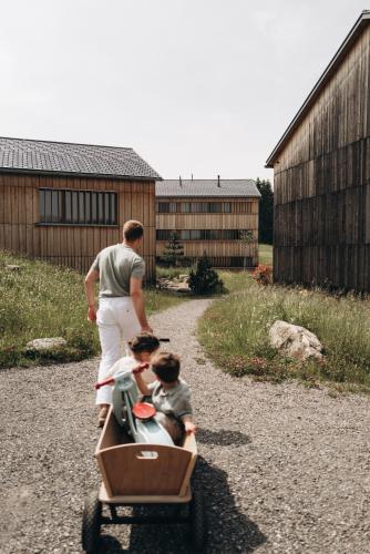 a man pushing a cart with two children in it at Fuchsegg Eco Lodge in Egg